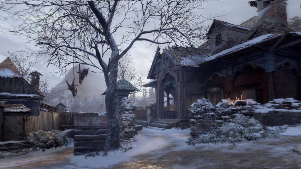 dilapidated house with a tree outside. Two goat heads hang from the tree.